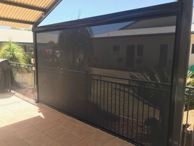Black Outdoor Shade Screen Partially Lowered on A Patio — Alice Mobile Blinds in Ciccone, NT