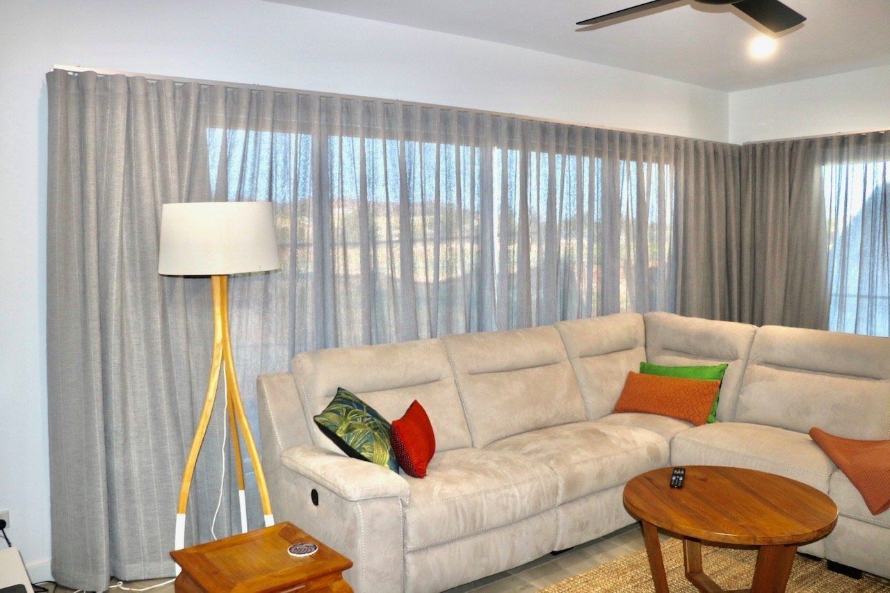 Living Room with Grey Curtains Beige and Sectional Sofa — Alice Mobile Blinds in Ciccone, NT