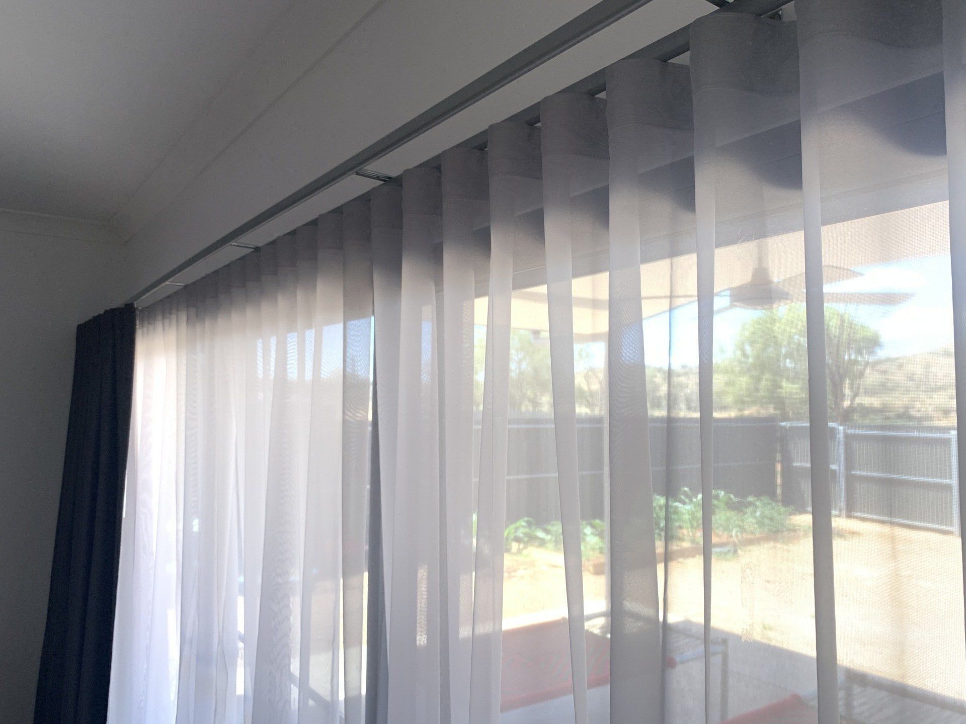 Sheer Grey Curtains Hanging from A Track — Alice Mobile Blinds in Ciccone, NT