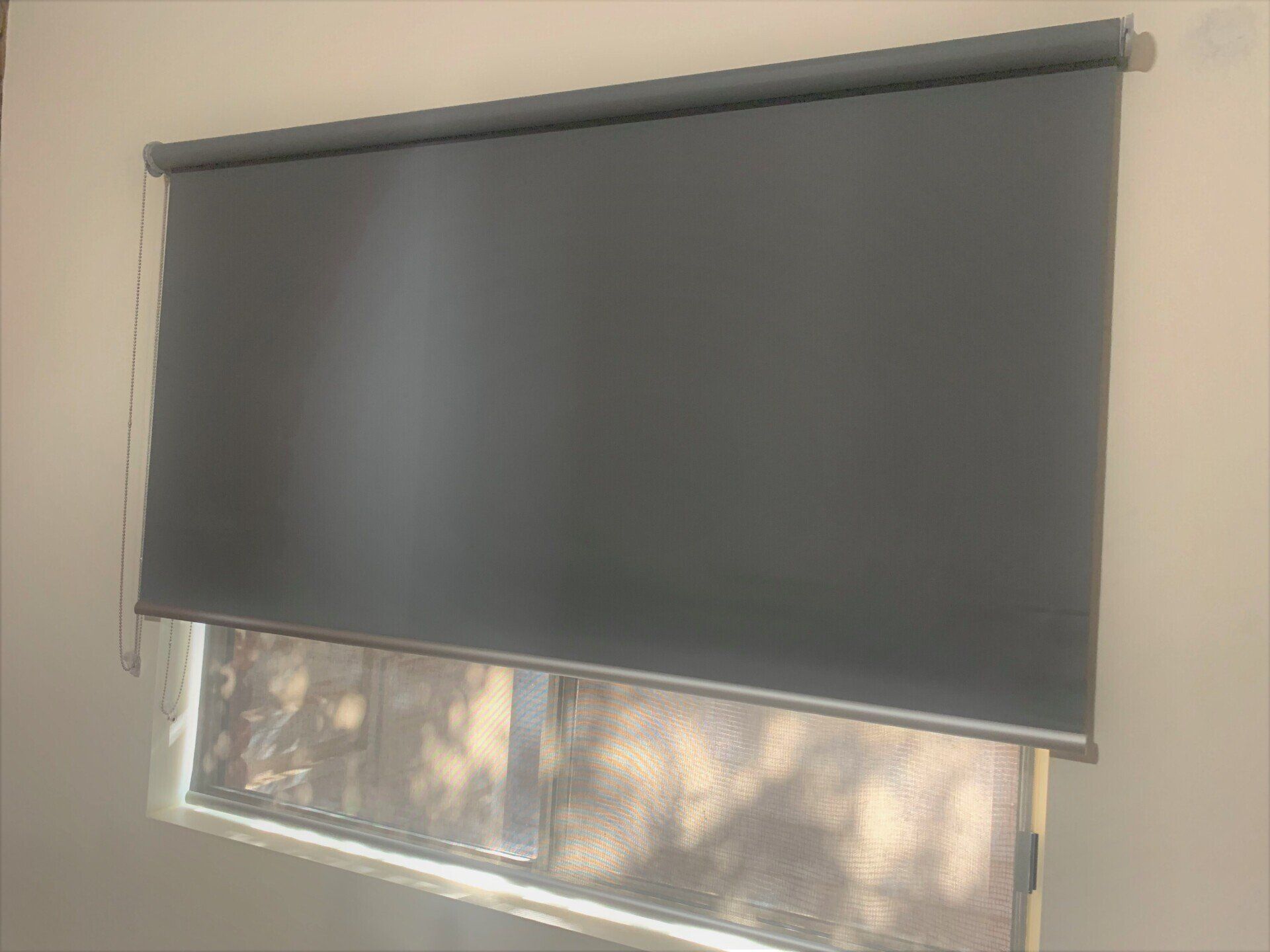 Grey Roller Blind Partially Covering a Window — Alice Mobile Blinds in Ciccone, NT