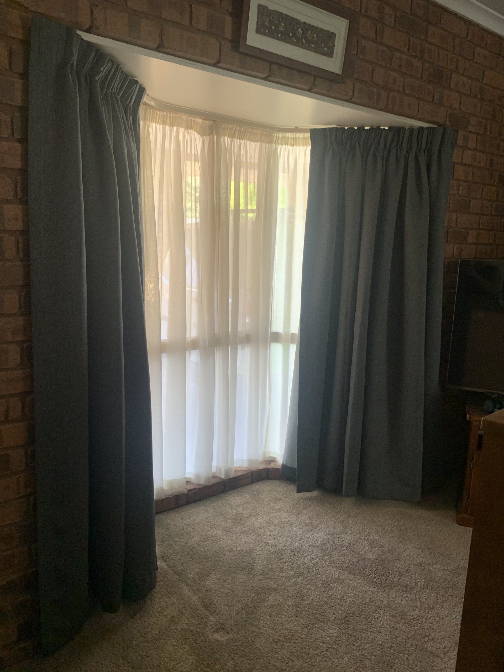 Grey Curtains Frame a Bay Window with Sheer White Curtains — Alice Mobile Blinds in Ciccone, NT