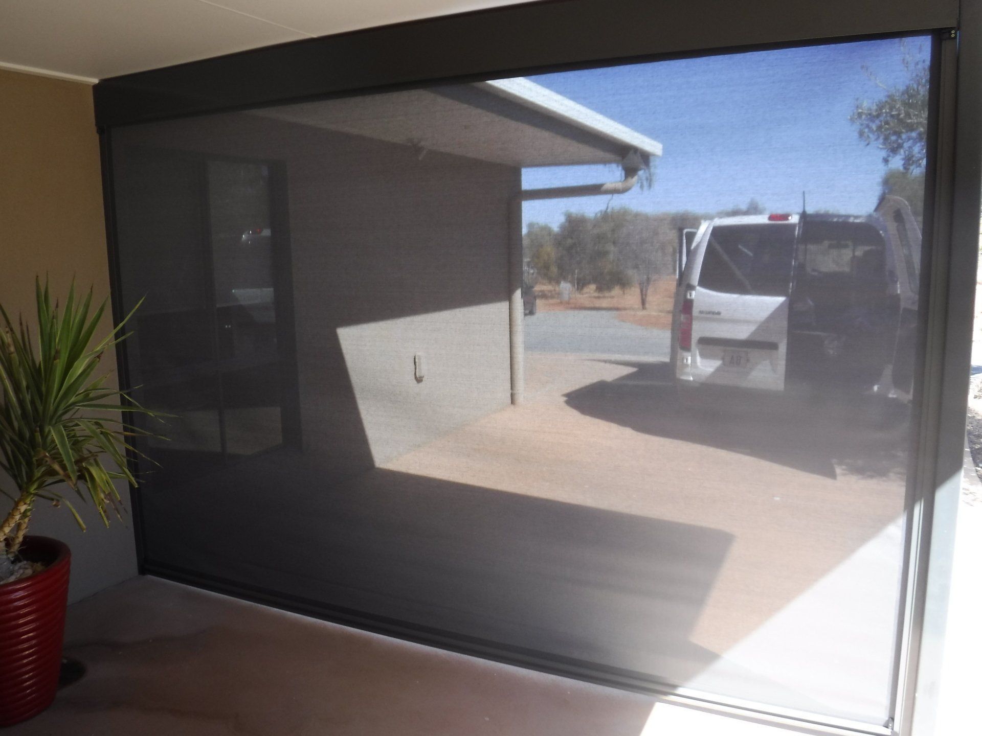 Dark Grey Outdoor Sun Screen Rolled Down on A Patio — Alice Mobile Blinds in Ciccone, NT