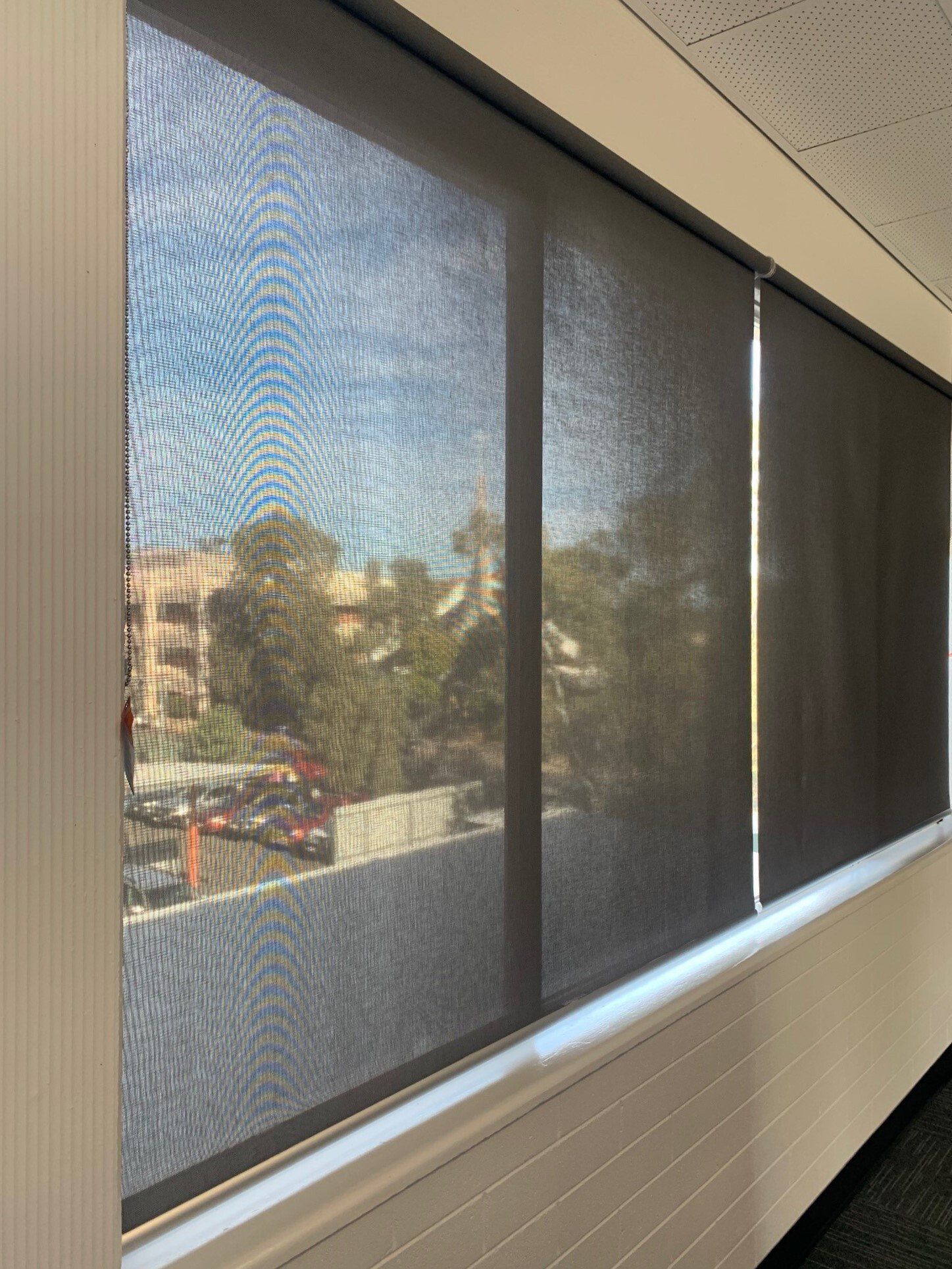 Black Roller Shades Cover Windows View of Buildings — Alice Mobile Blinds in Ciccone, NT