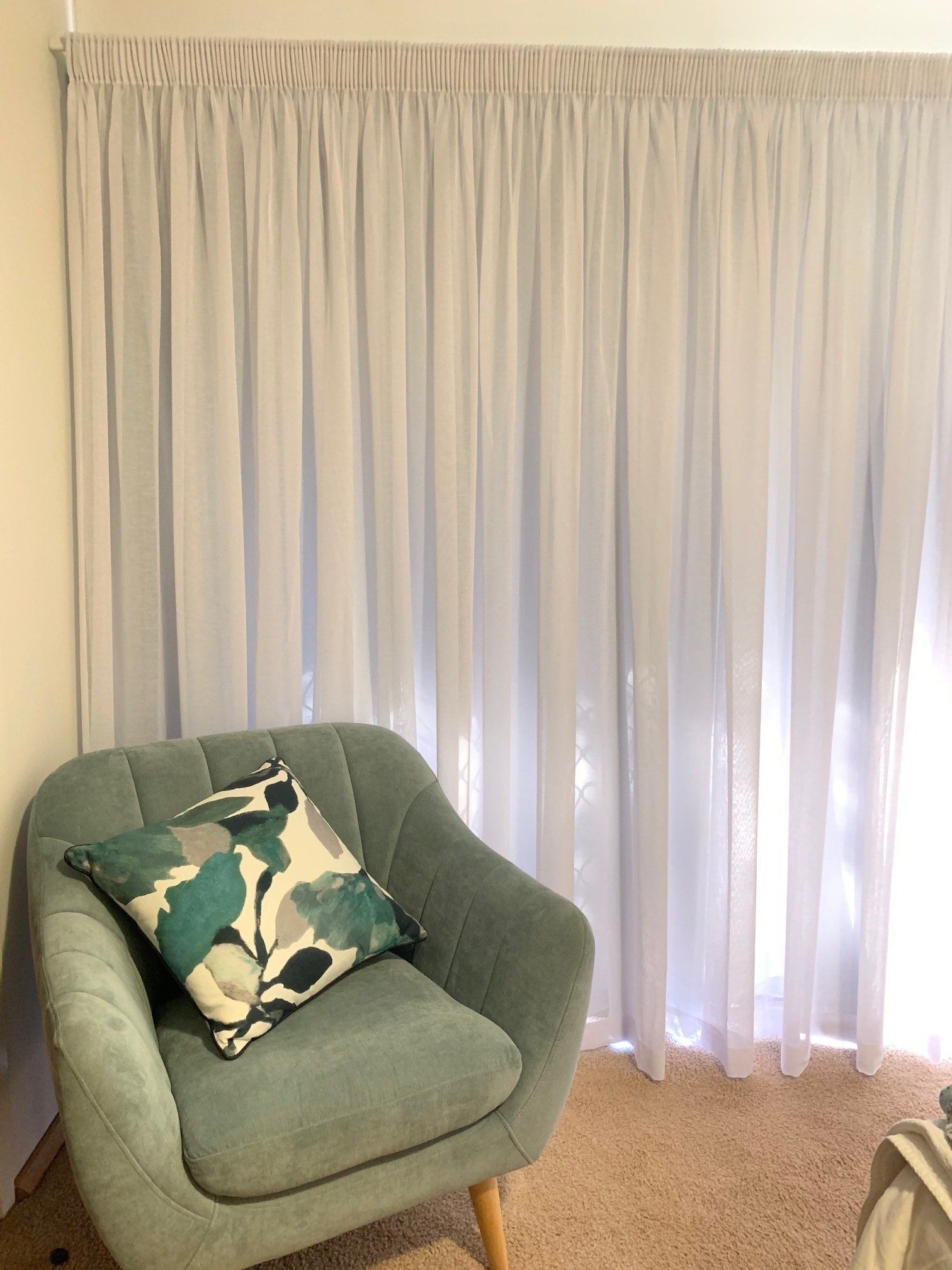 A Sheer White Curtain Hangs Behind a Teal Armchair — Alice Mobile Blinds in Ciccone, NT