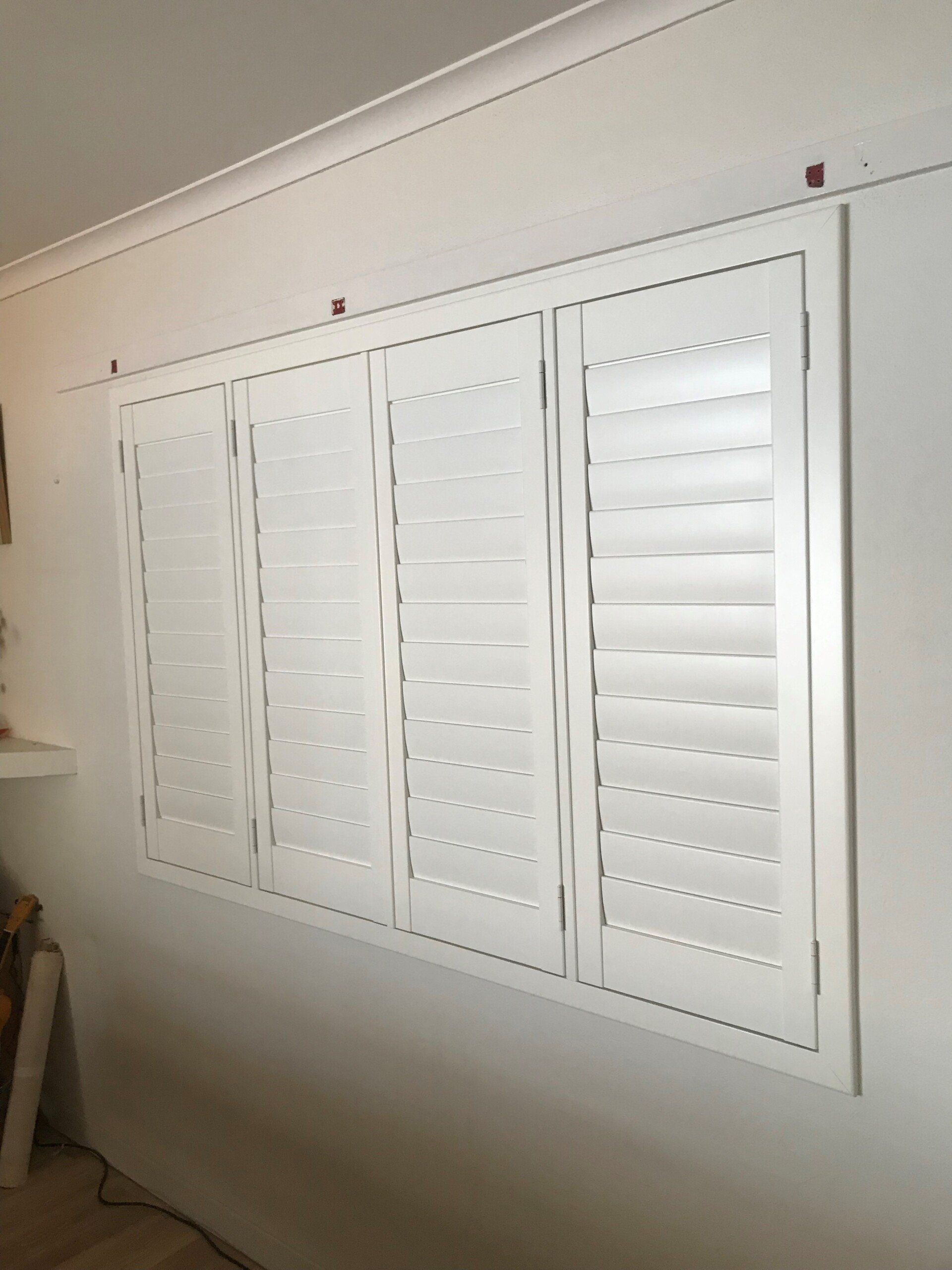 White Interior Shutters on A White Wall — Alice Mobile Blinds in Ciccone, NT