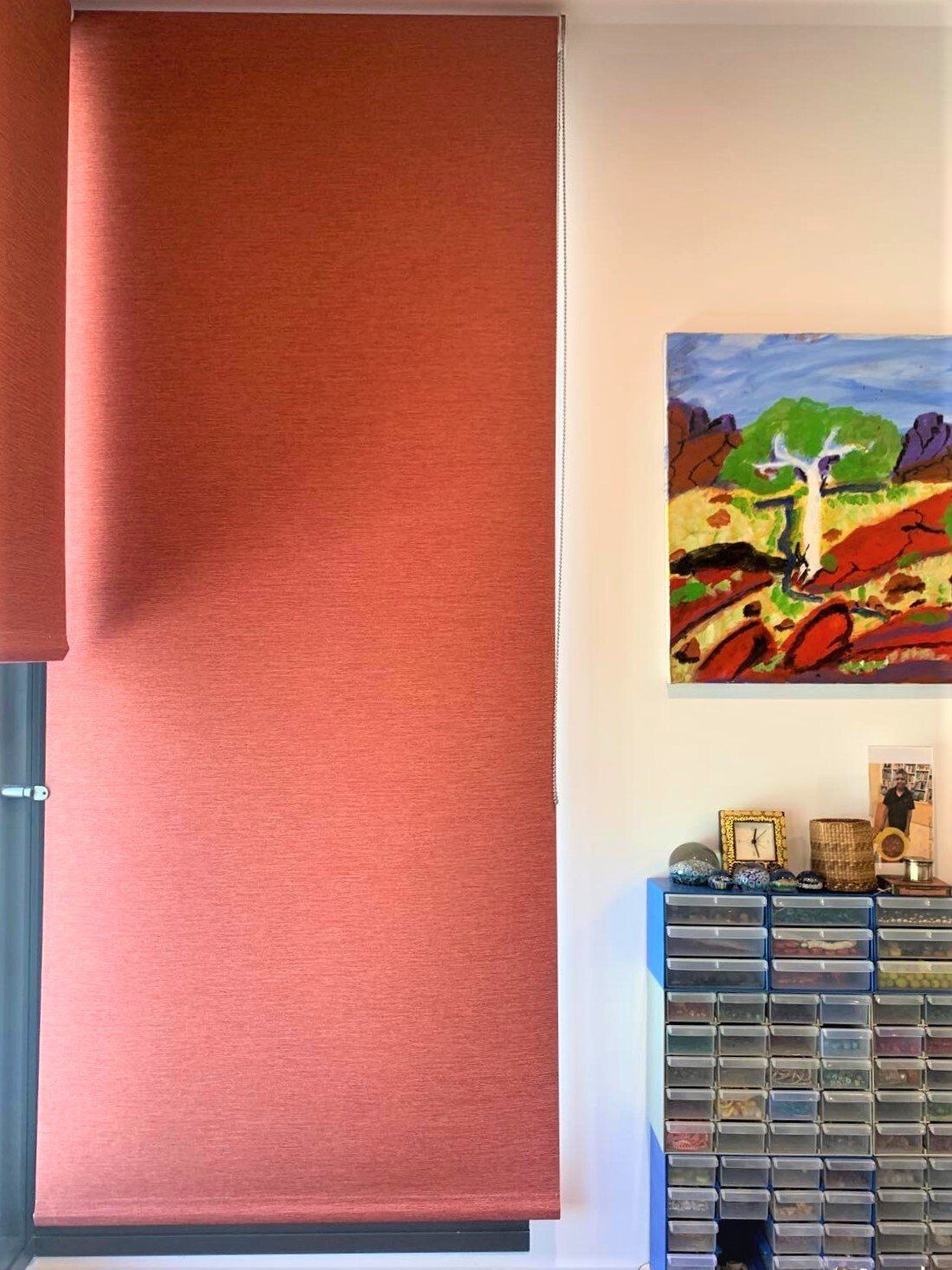 Coral-Coloured Roller Blinds Partially Cover a Window — Alice Mobile Blinds in Ciccone, NT