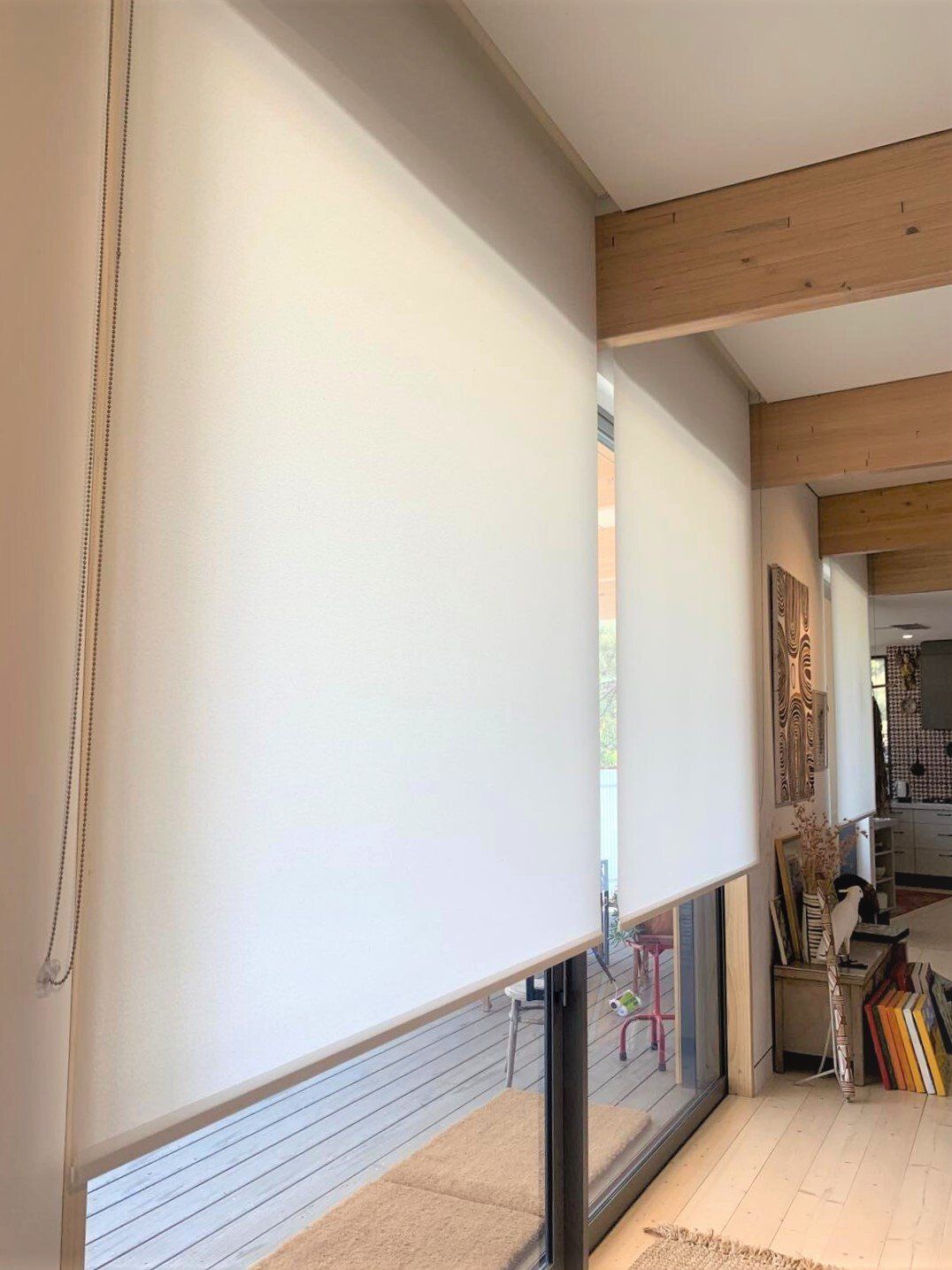 White Roller Shades Cover Windows in A Room with Light-Coloured Wood — Alice Mobile Blinds in Ciccone, NT