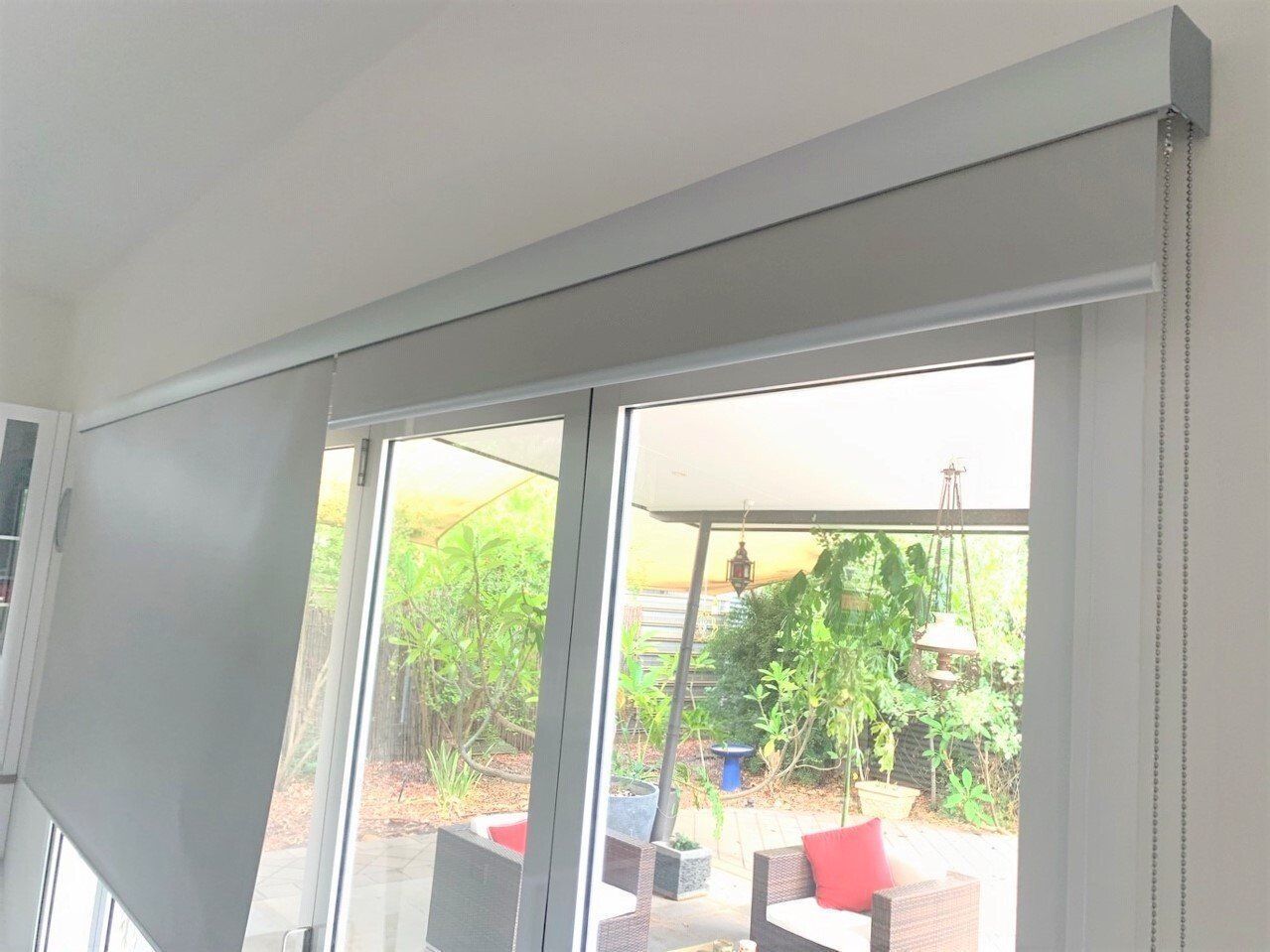 Grey Roller Shade Partially Covering a Glass Sliding Door — Alice Mobile Blinds in Ciccone, NT