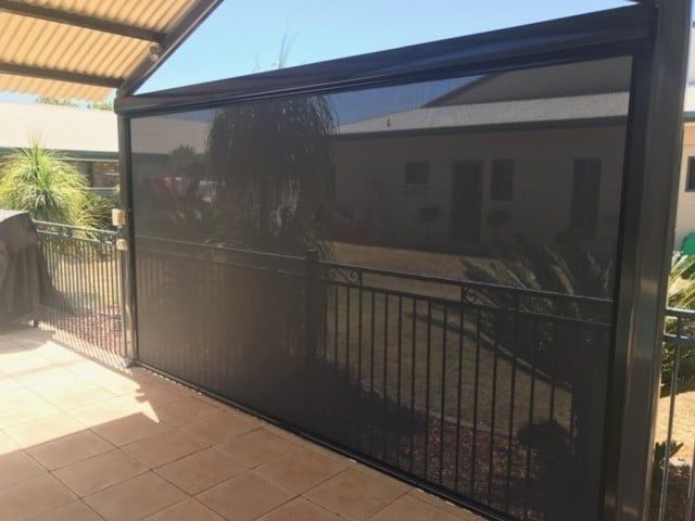 Black Outdoor Screen Partially Lowered on A Patio — Alice Mobile Blinds in Ciccone, NT