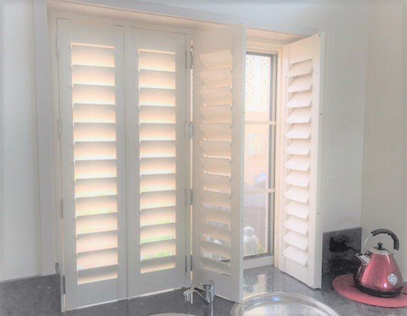 White Shutters on A Kitchen Window One Shutter Open Sunlight Visible — Alice Mobile Blinds in Ciccone, NT