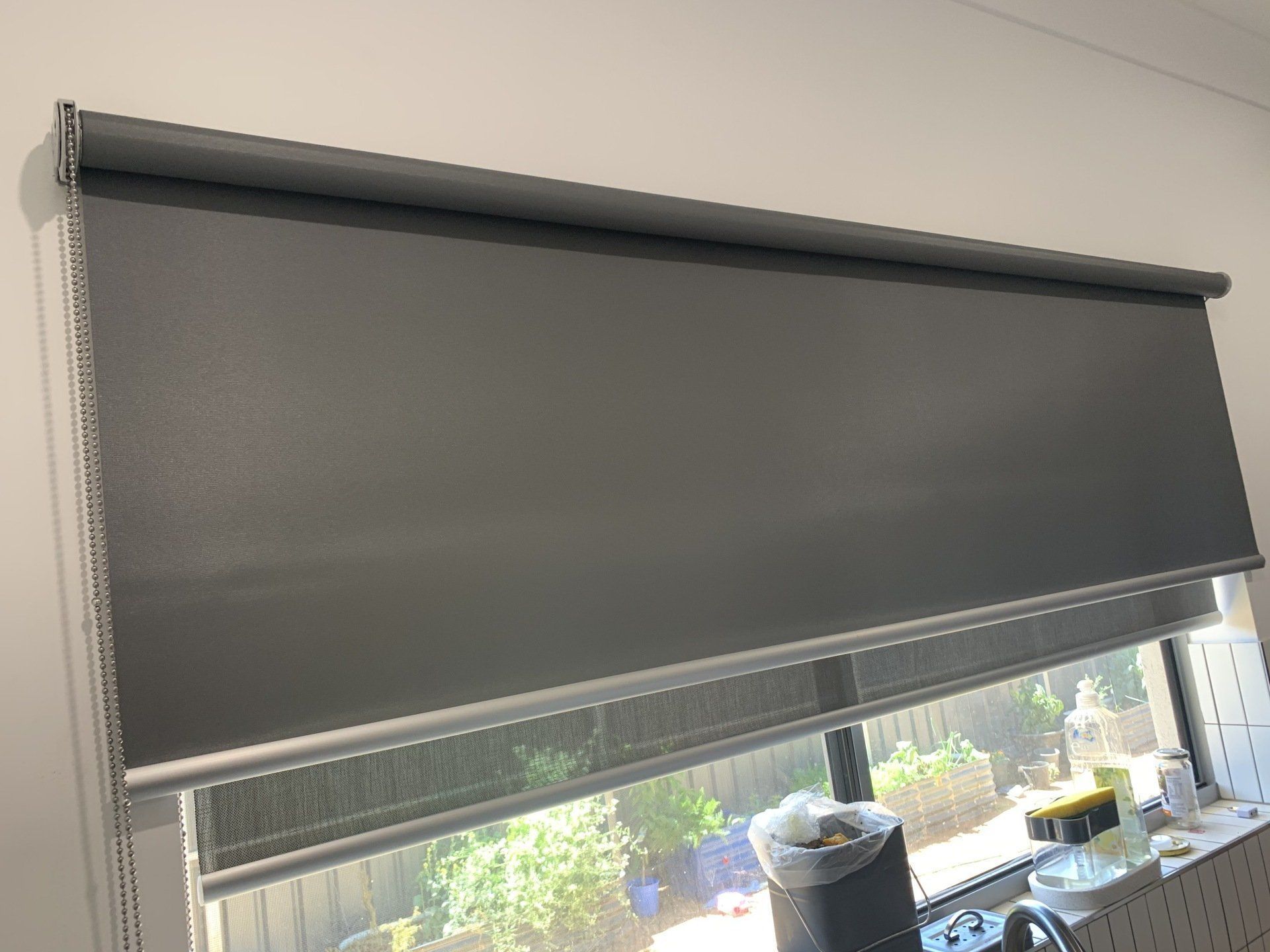 Grey Roller Blinds Covering a Window Partially Drawn — Alice Mobile Blinds in Ciccone, NT