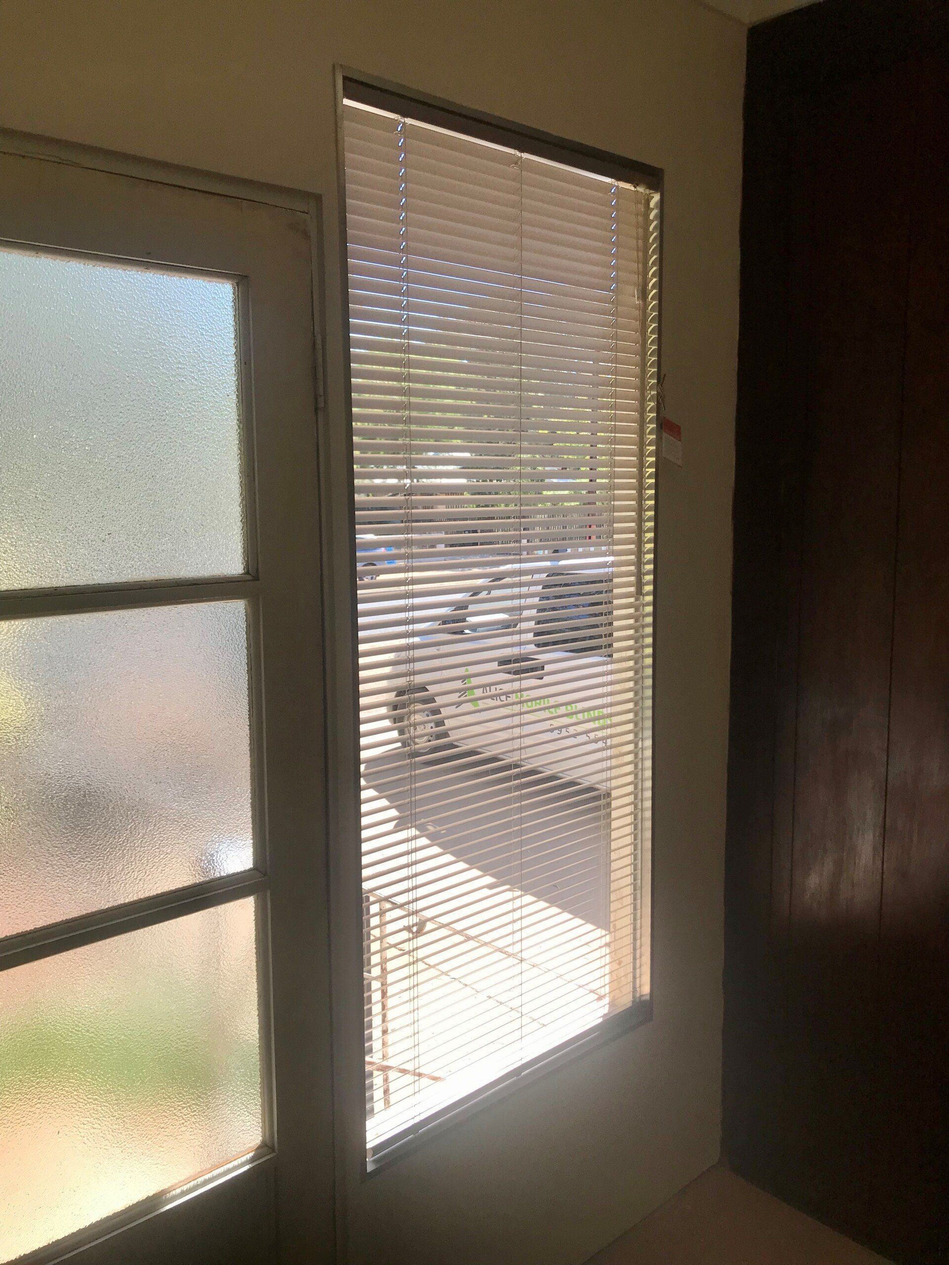 Door with Frosted Glass Panel Next to A Window with Closed Blinds — Alice Mobile Blinds in Ciccone, NT