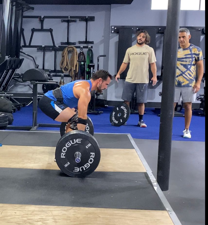 A man is lifting a rogue barbell in a gym