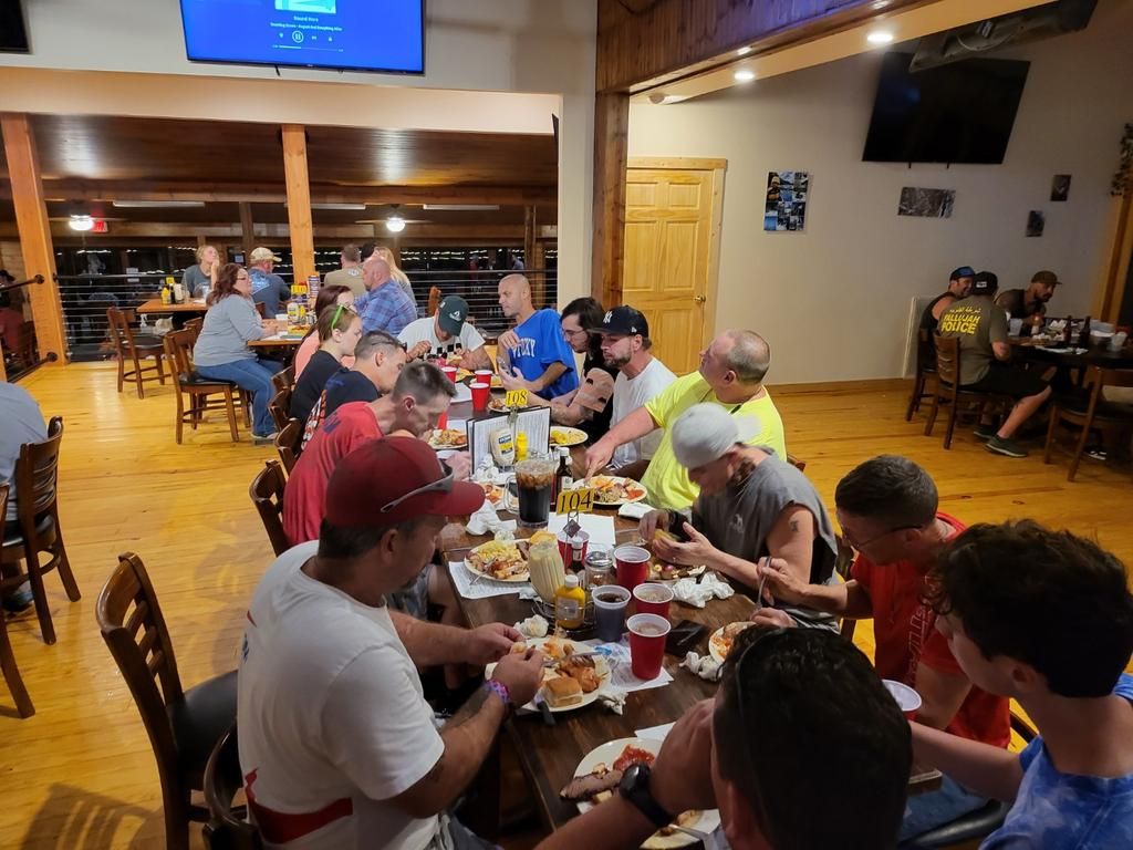 A group of people are sitting at tables in a restaurant eating food.