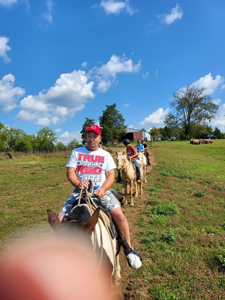 A man is riding a horse in a field with other people.