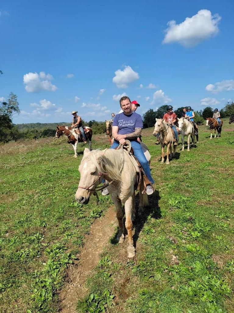 A man is riding a horse in a field with other people.