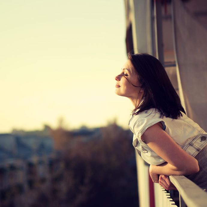 a woman leaning on a railing with her eyes closed