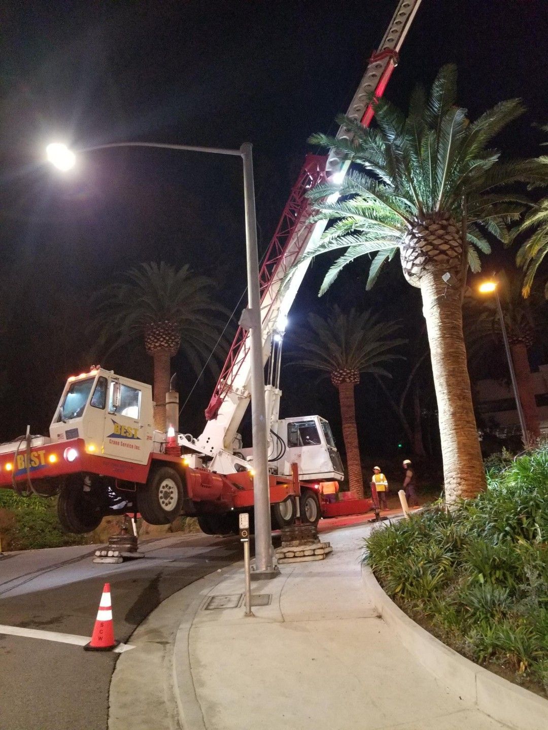 A crane is working on a street light at night - San Diego, CA - Best Crane Service Inc.
