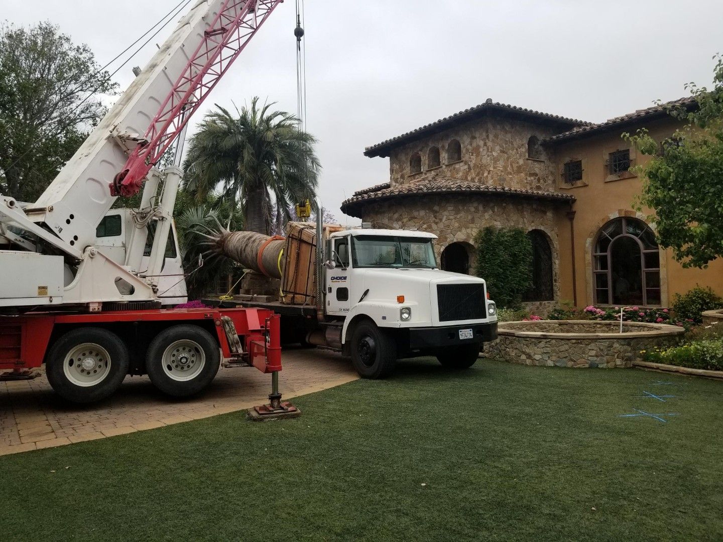 A truck with a crane attached to it is parked in front of a house - San Diego, CA - Best Crane Service Inc.