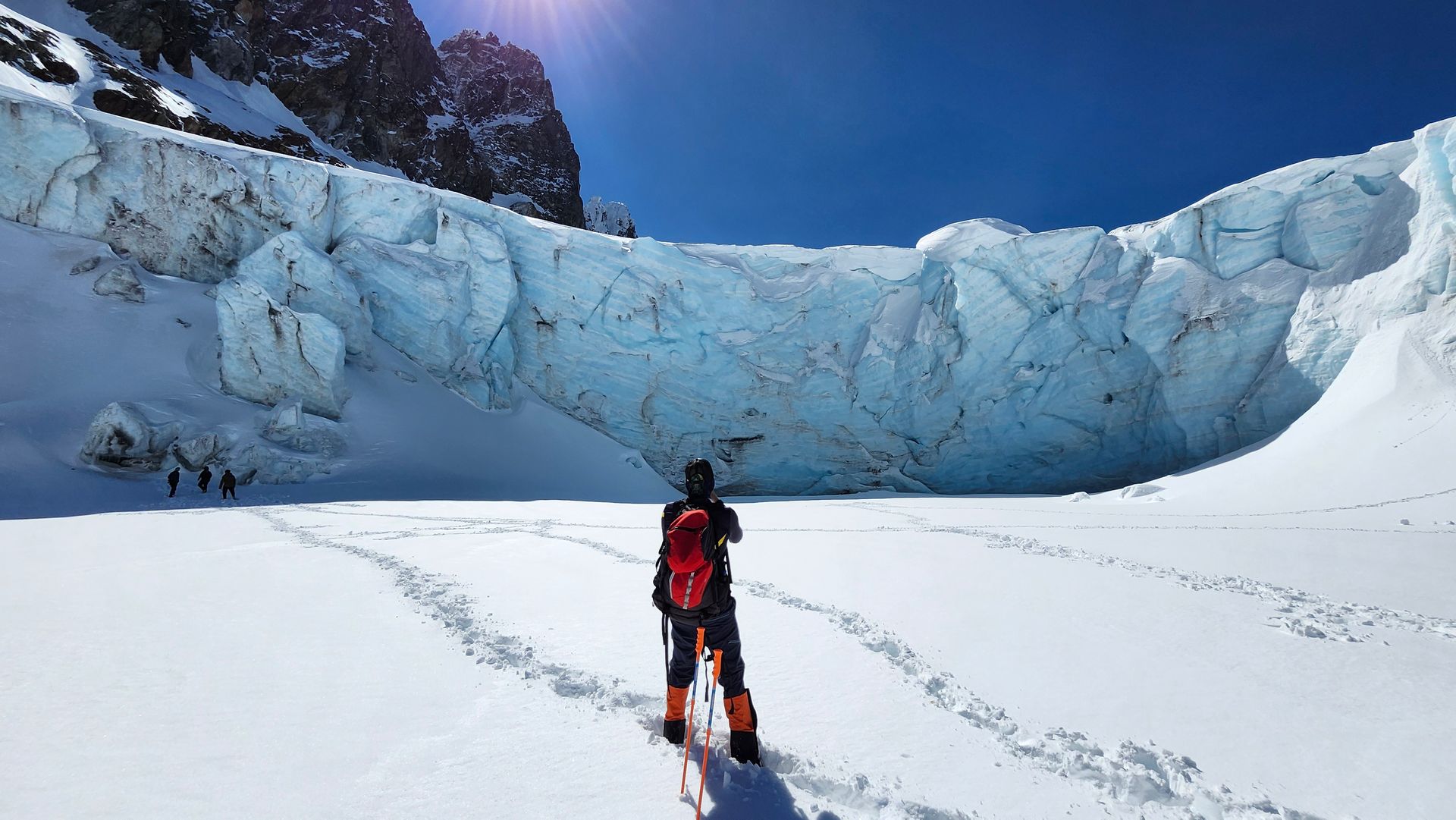 Persona parada al lado de un glaciar 