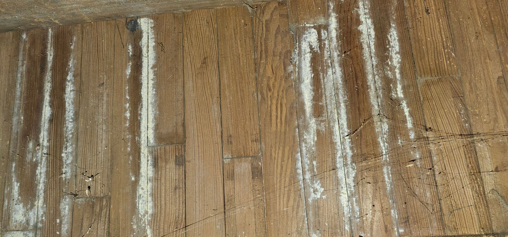Wood planks with white streaks running across them.