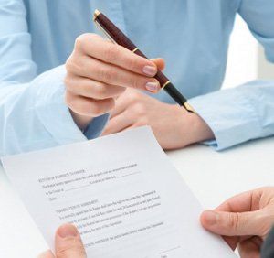 handing over a pen to sign a document