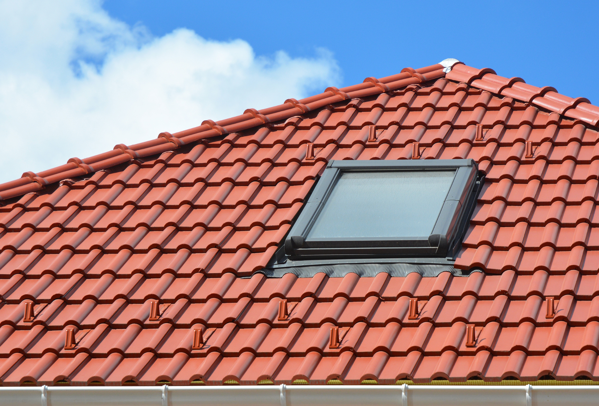 A red tiled roof with a skylight in the middle