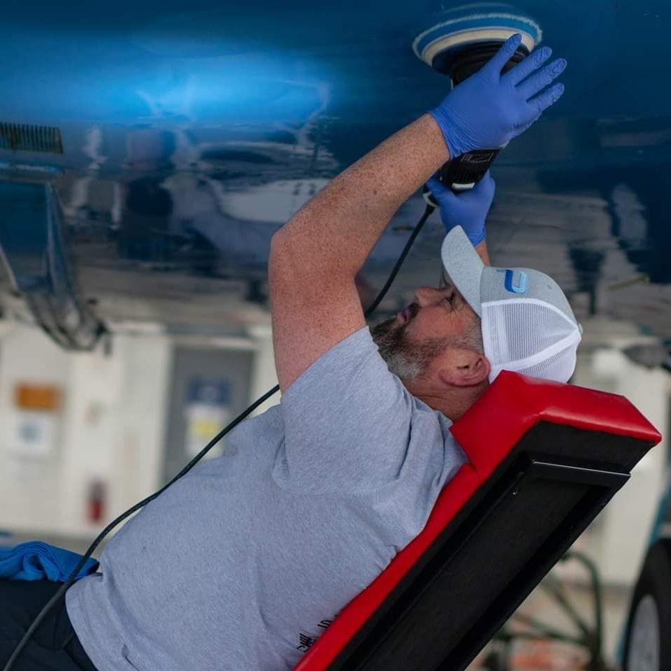 A man is polishing the ceiling of a boat