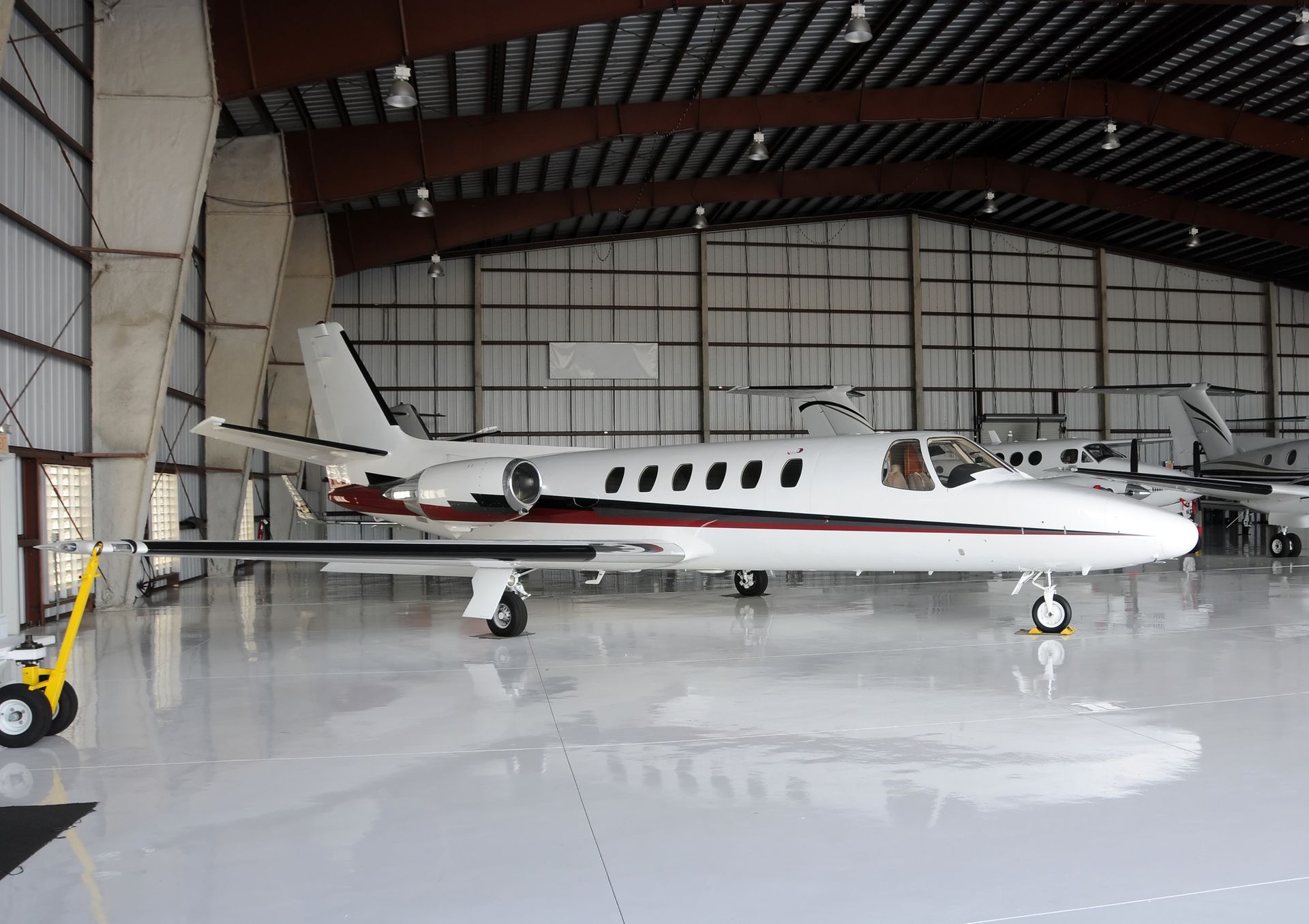 A private jet is parked inside of a hangar