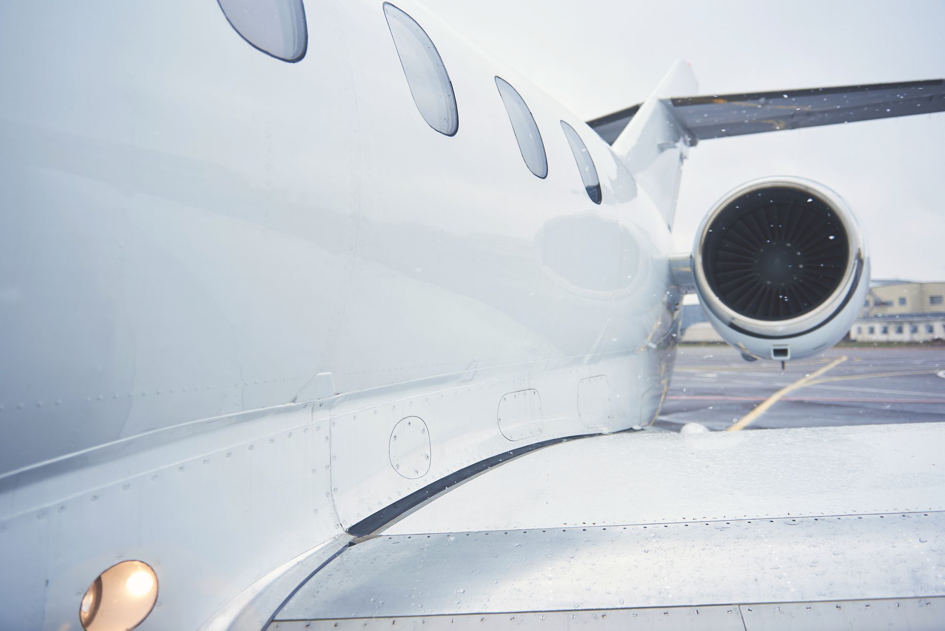 A white airplane is parked on the tarmac at an airport
