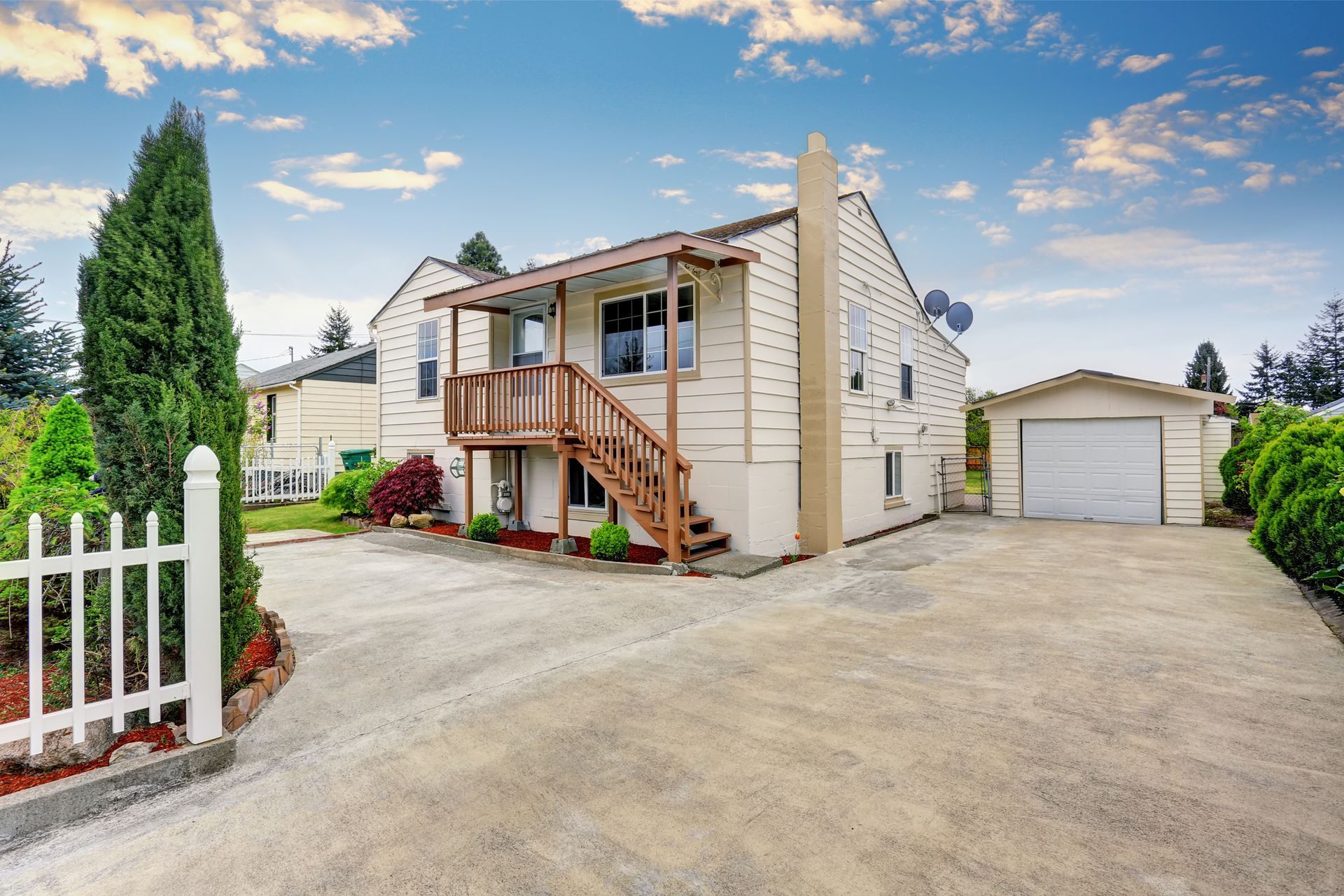A house with a garage and a driveway in front of it.