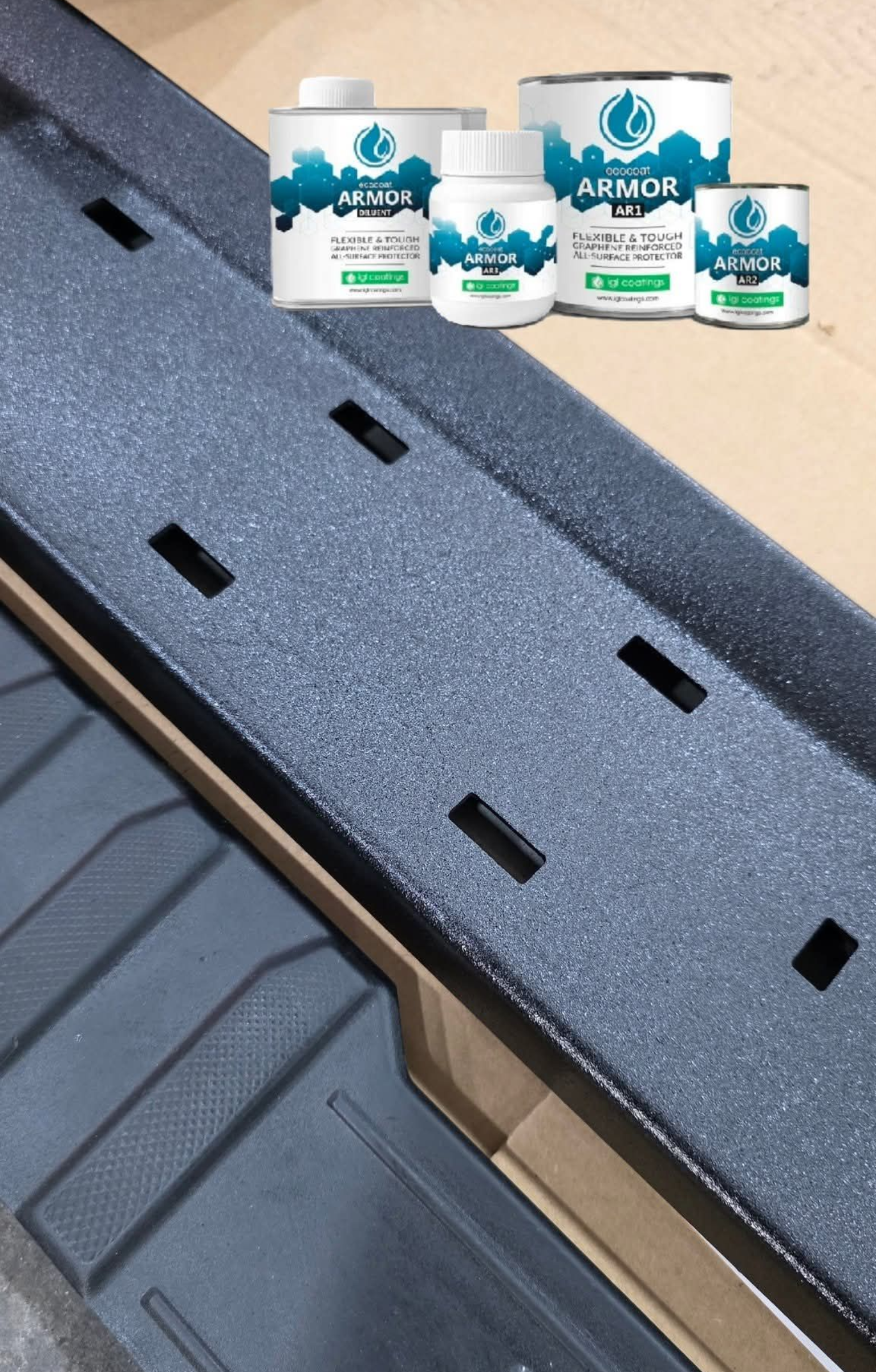 Close-up of a truck side step coated with a textured, dark gray paint, with several cans of