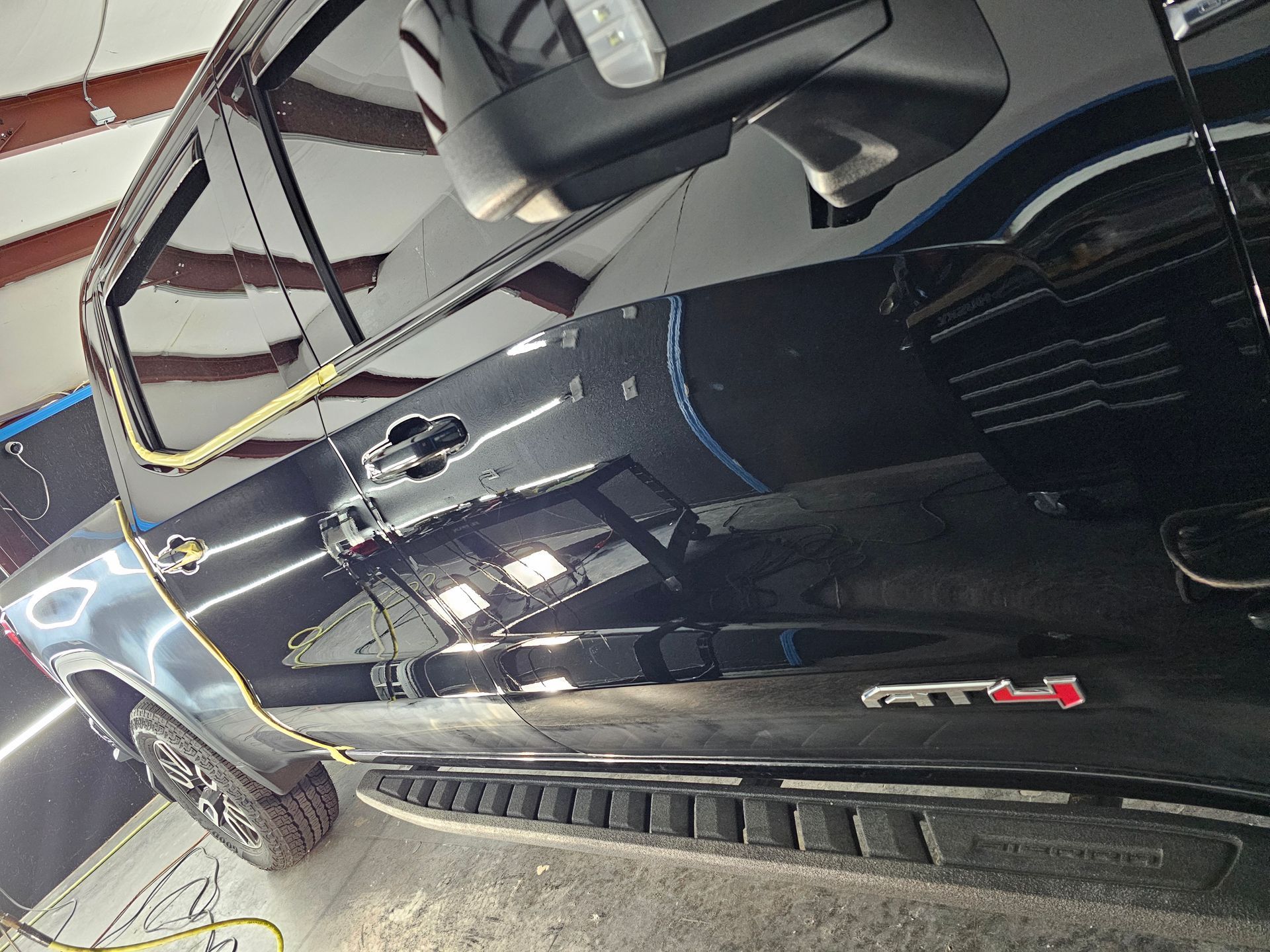 A black truck is parked in a garage.