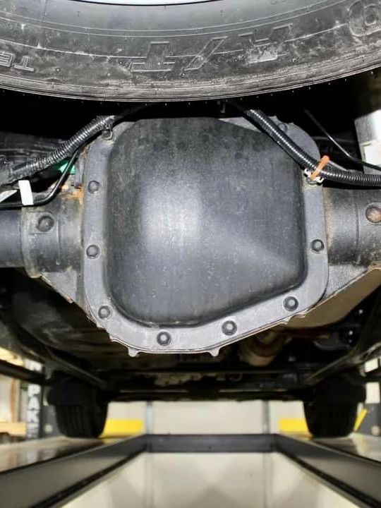 A close up of the underside of a car on a lift.