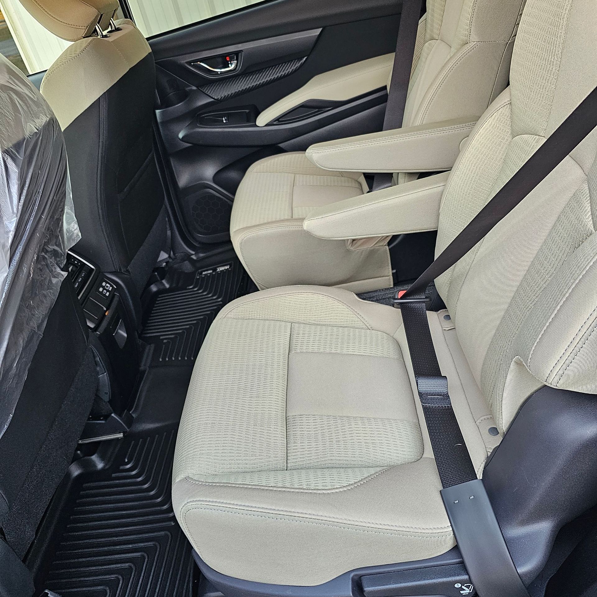 The back seat of a car with a seat belt on it.
