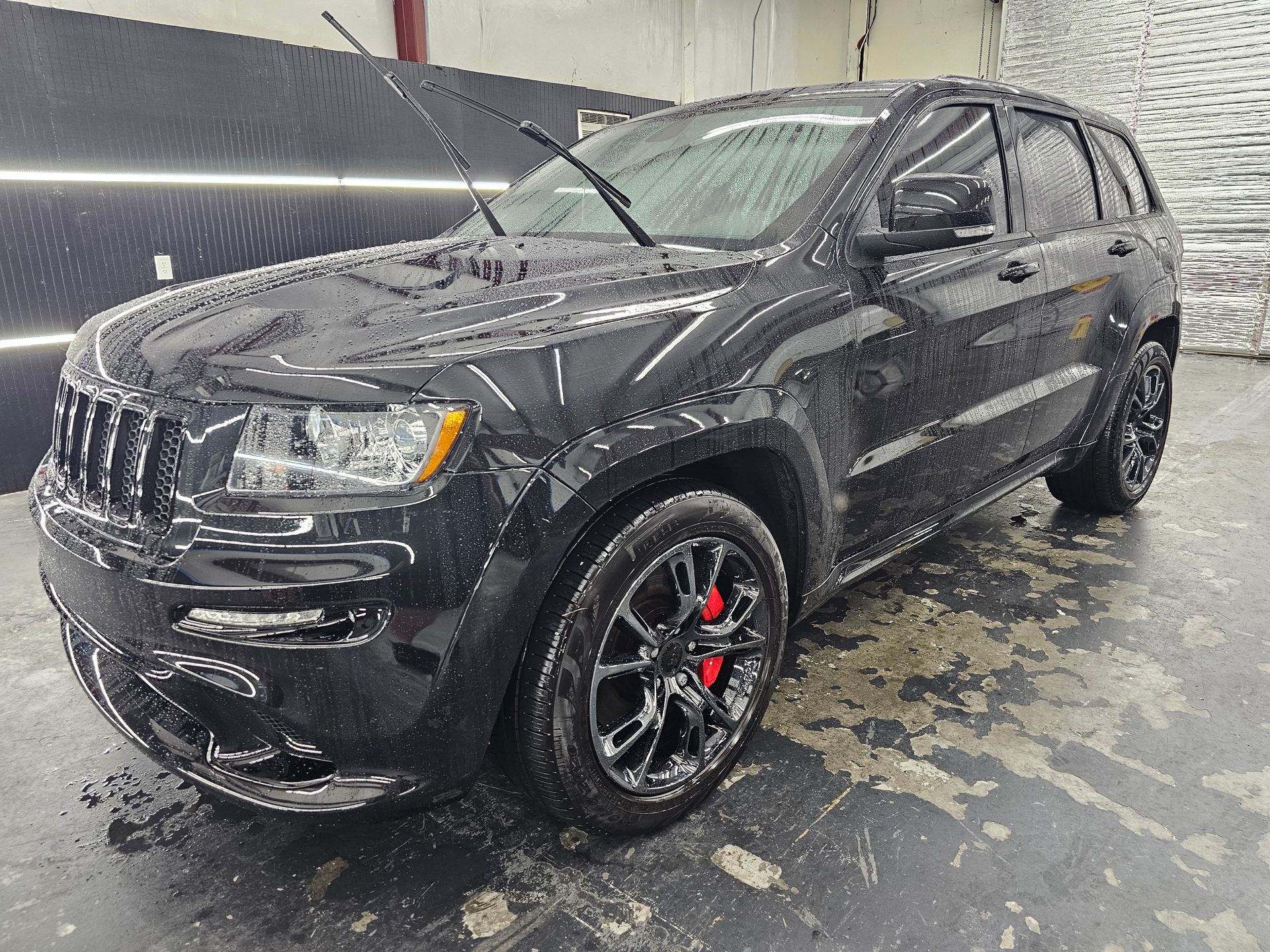 A black jeep grand cherokee is parked in a garage.