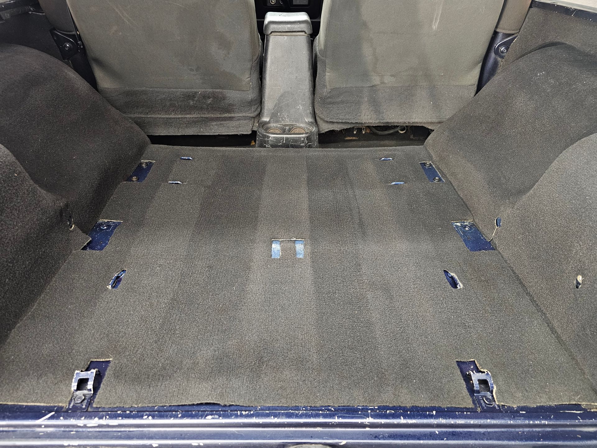 The back of a car with a carpeted floor and seats.