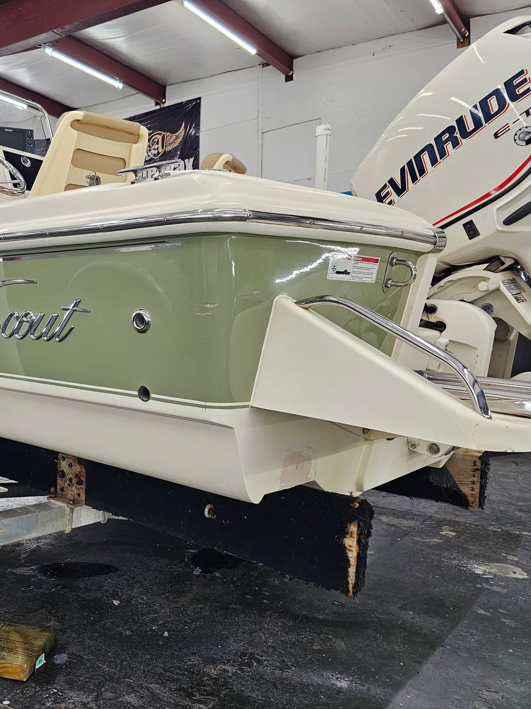 A boat with a evinrude engine is parked in a garage.