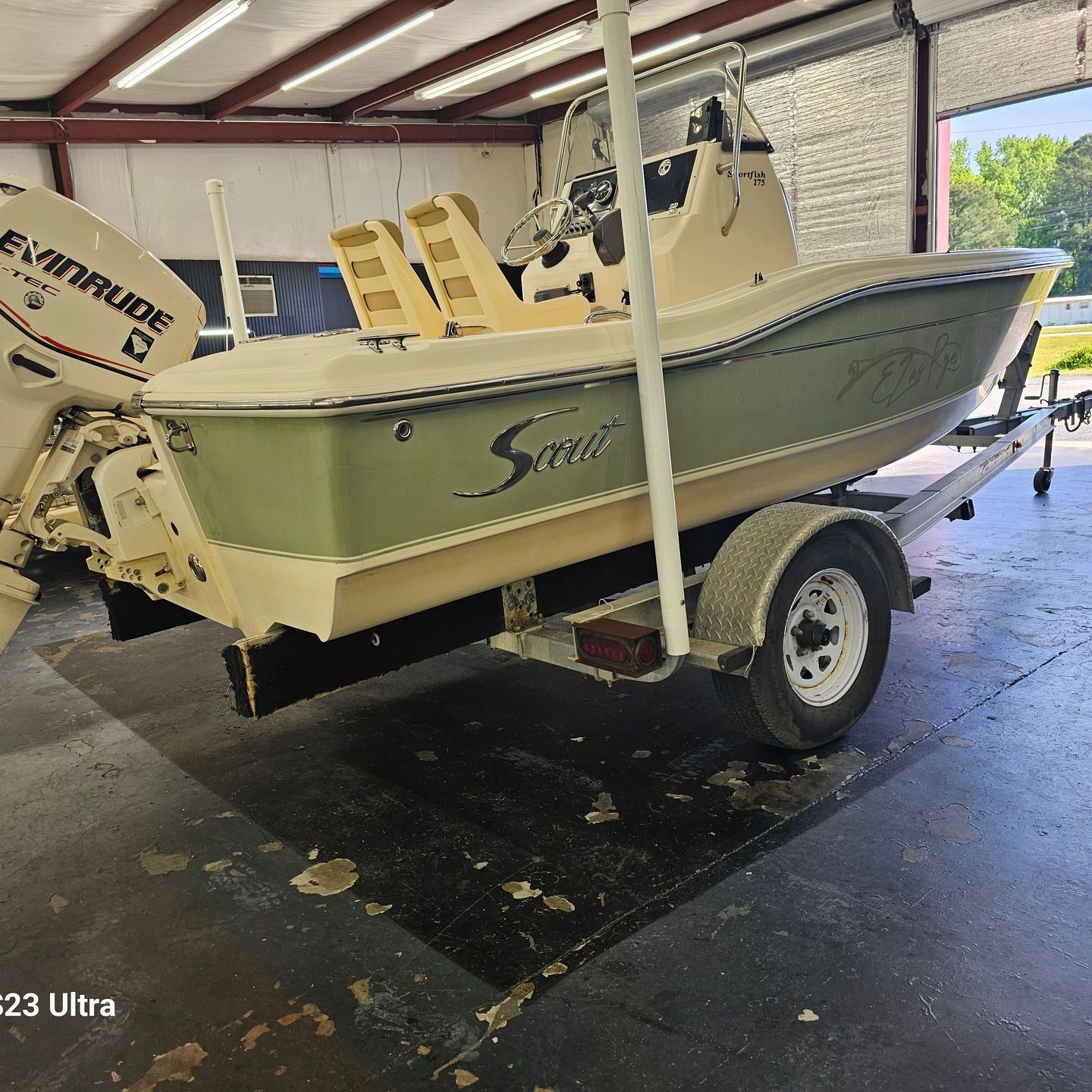 A boat on a trailer with a evinrude engine