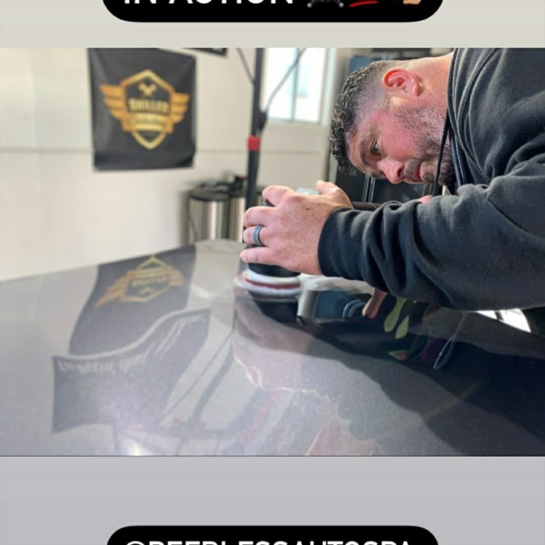 A man is polishing the hood of a car