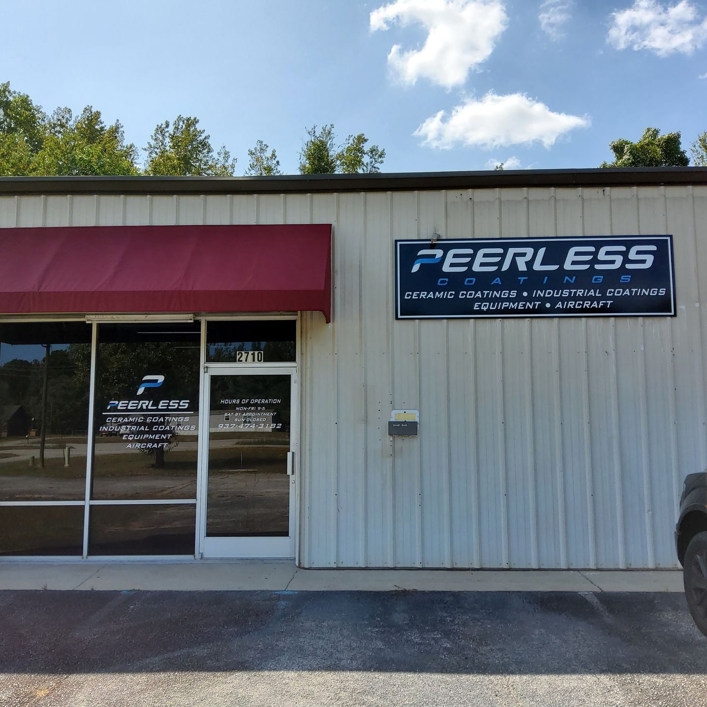 A white building with a sign that says peerless racing