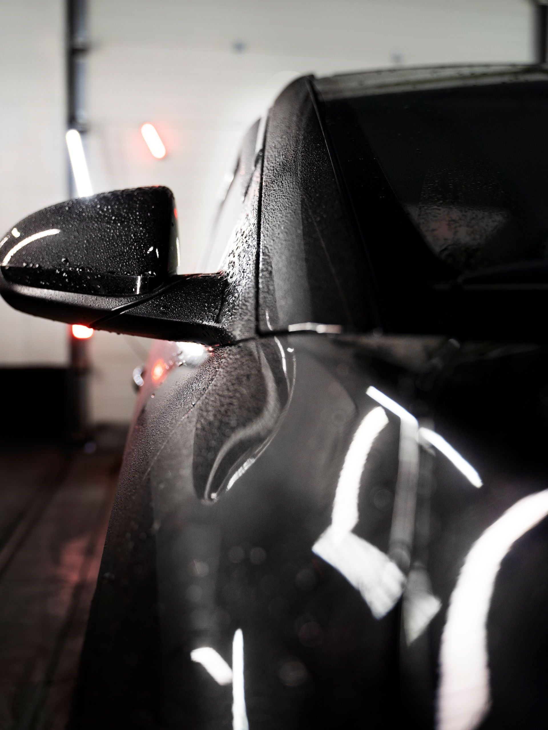A close up of a car 's side mirror with water drops on it