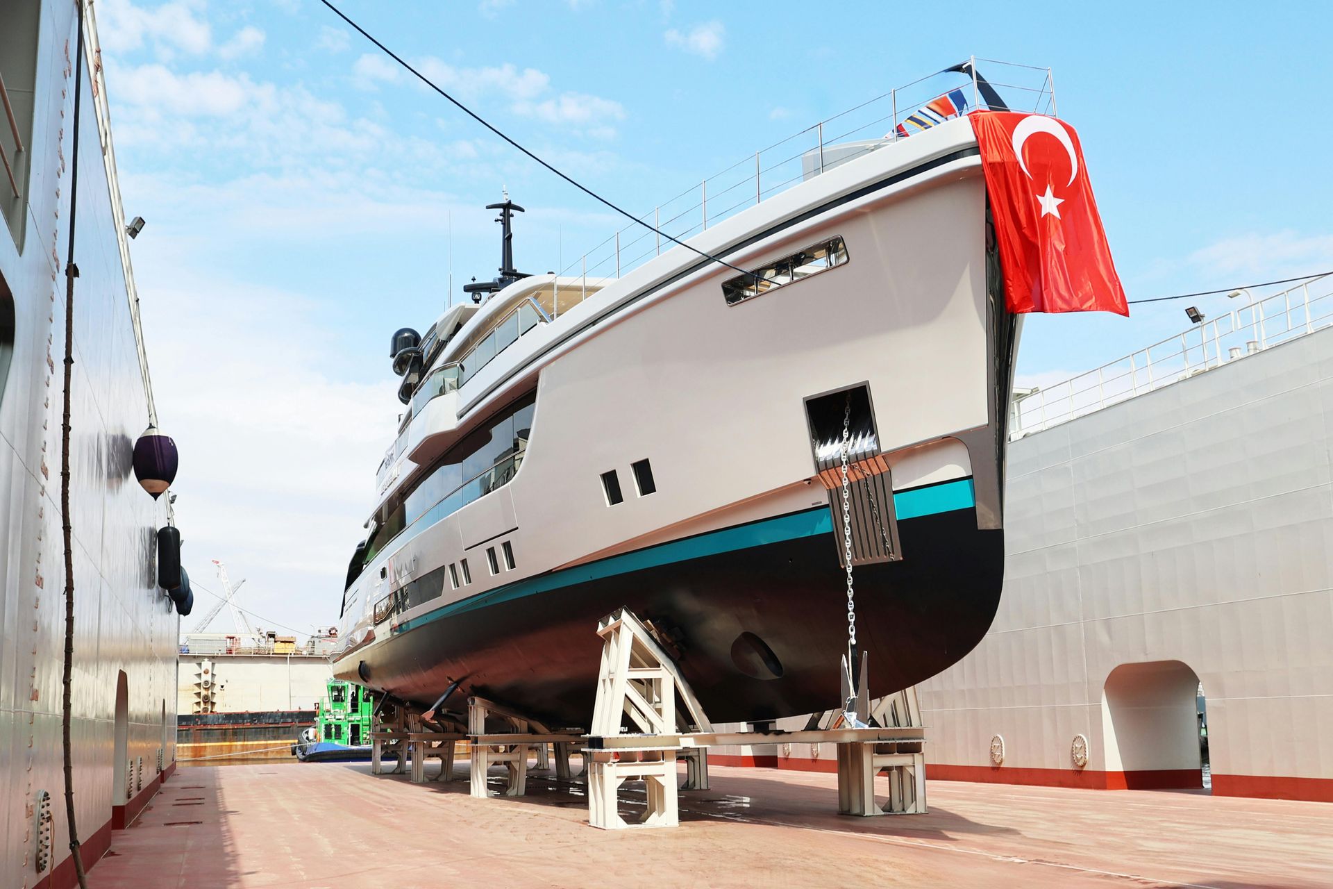A large yacht is sitting on a dock next to a large ship.