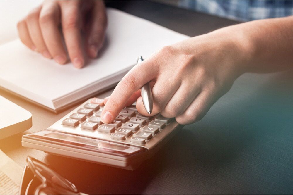 A Person Is Using A Calculator And Writing On A Notebook — BookSenz In Aberglasslyn, NSW