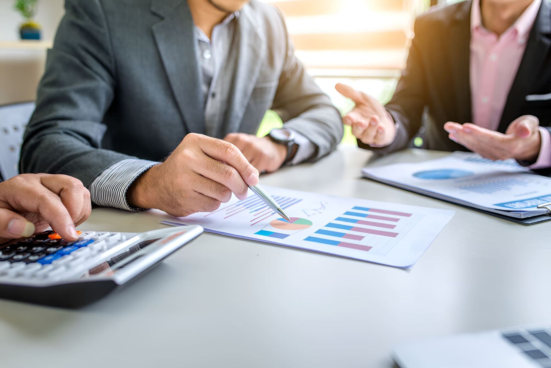 Two Men Are Sitting At A Table With A Calculator And A Pen — BookSenz In Rutherford, NSW