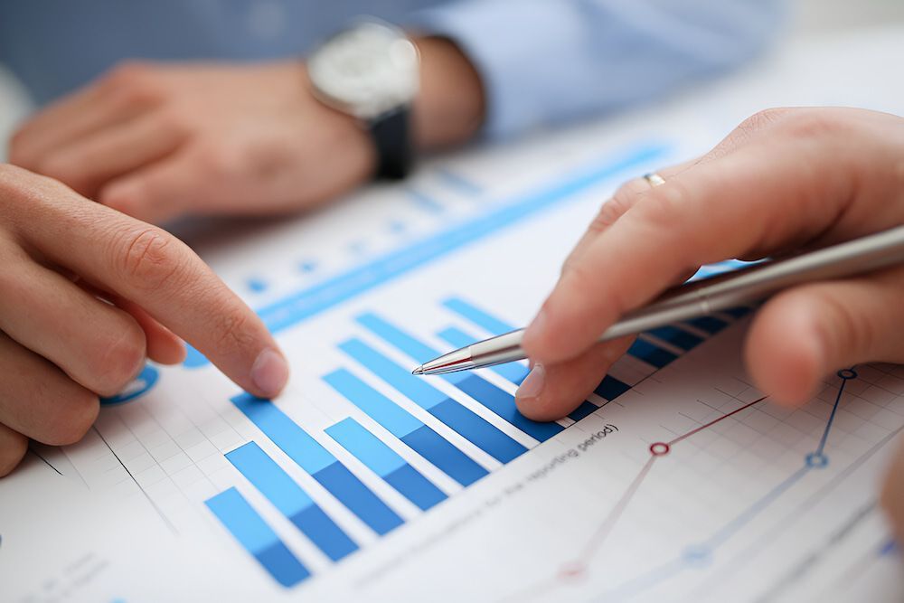 A Person Is Pointing At A Graph On A Piece Of Paper With A Pen — BookSenz In Muswellbrook, NSW
