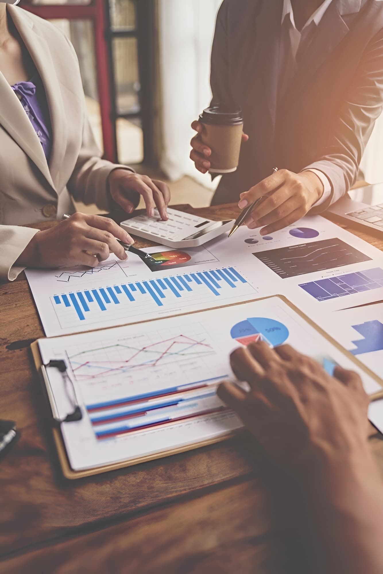 A Man And A Woman Are Sitting At A Table Looking At Charts And Graphs — BookSenz In Aberglasslyn, NSW