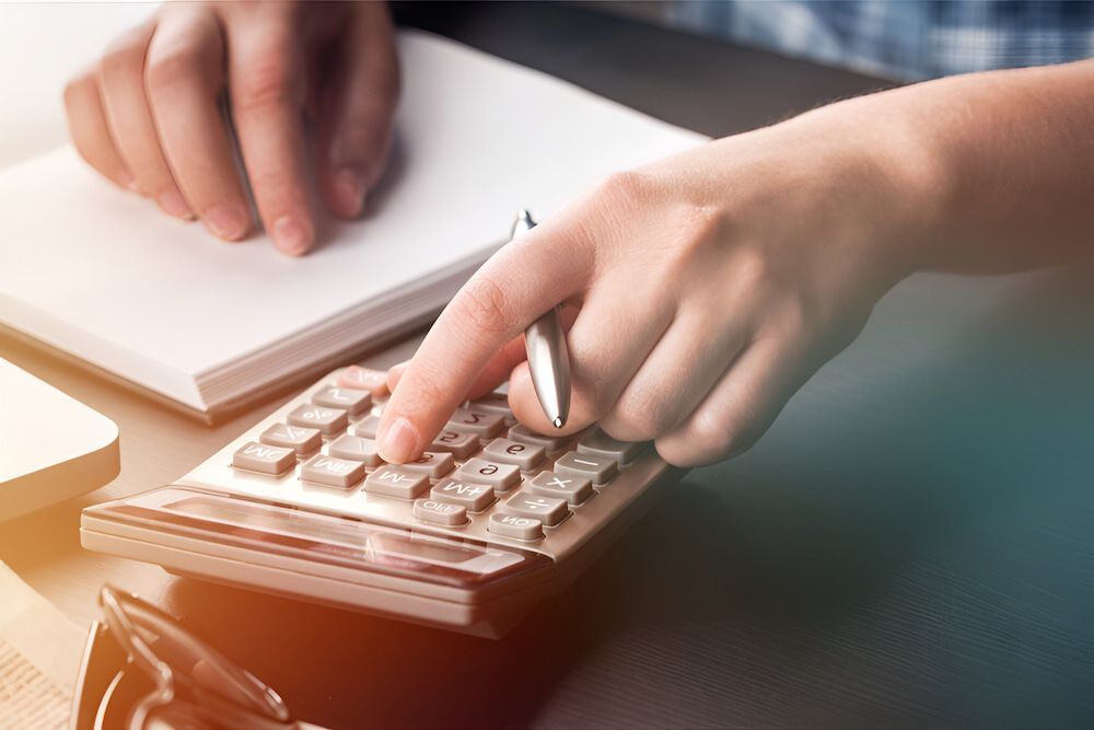 A Person Is Using A Calculator And Writing On A Notebook — BookSenz In Aberglasslyn, NSW