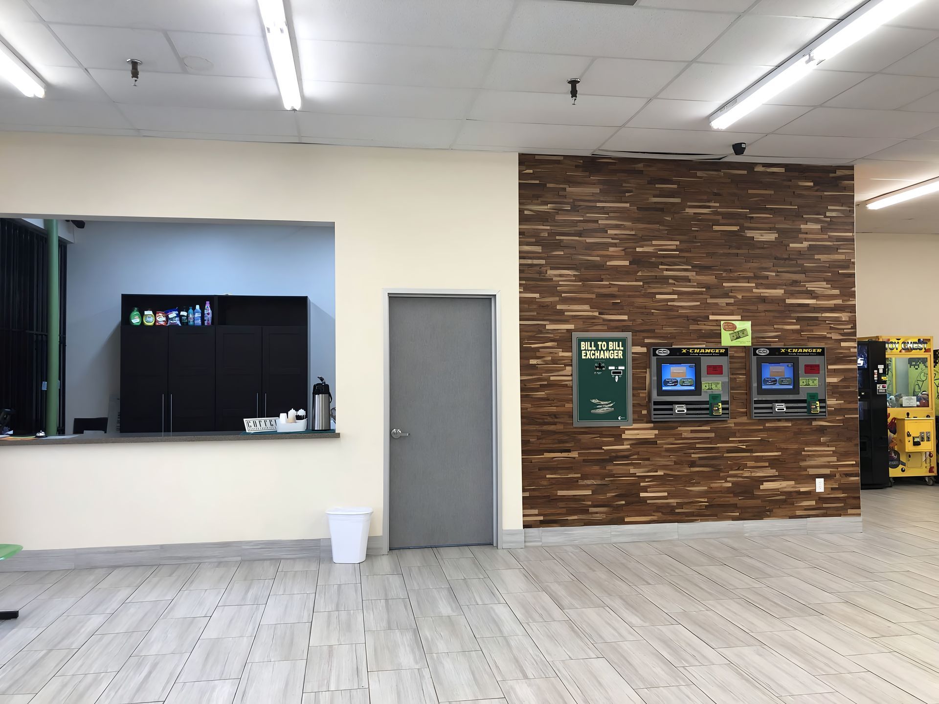 A large empty room with a wooden wall and a door