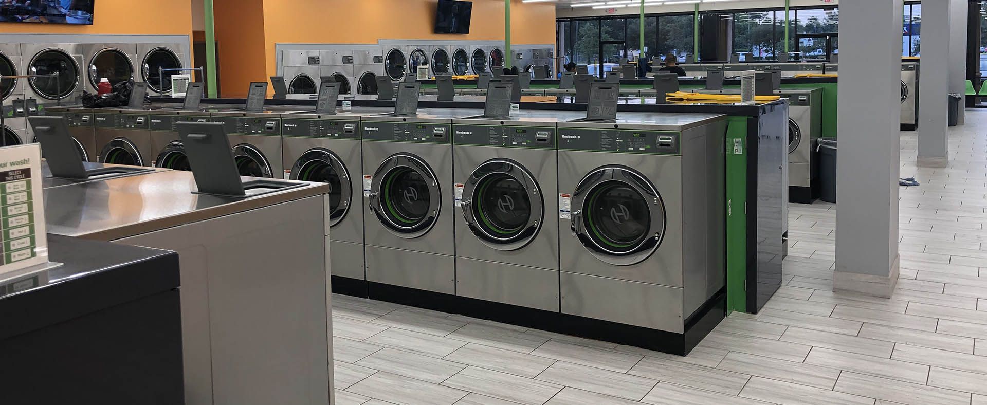 A laundromat filled with lots of washing machines and dryers.